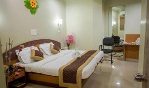 a bedroom with a large bed in a room at Vora Corporate Inn in Nagpur