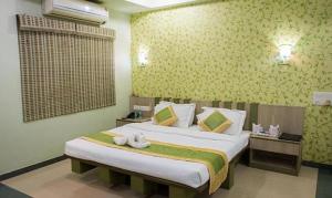 a bedroom with a large bed in a room at Vora Corporate Inn in Nagpur