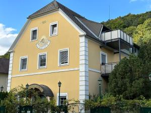 a yellow building with a balcony on the side of it at Appartements am Landschaweg in Weiz