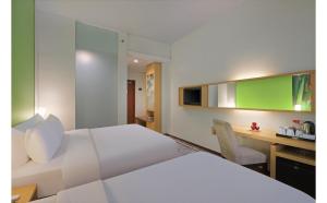 Ένα ή περισσότερα κρεβάτια σε δωμάτιο στο Quest Hotel Simpang Lima - Semarang by ASTON