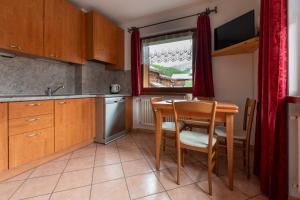 a kitchen with a table and chairs and a sink at Appartamenti Brunnlein in Livigno