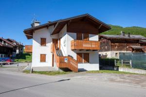 een wit huis met houten balkons in een straat bij Appartamenti Brunnlein in Livigno