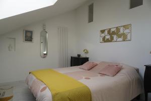 ein Schlafzimmer mit einem großen Bett mit zwei rosa Kissen in der Unterkunft Le Domaine du Moulin 28 in Bailleau-lʼÉvêque