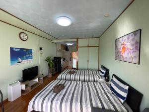 a room with two beds and a television in it at NAGO Sakura Resort Inn - Vacation STAY 14445v in Nago