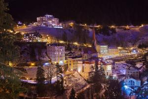 a view of a town at night with lights at Panorama Spa Lodges DAS.SCHILLER in Bad Gastein