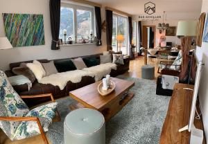 a living room with a couch and a table at Panorama Spa Lodges DAS.SCHILLER in Bad Gastein