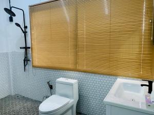 にあるBan Sam Bai Thaoのバスルーム(トイレ、洗面台付)、窓が備わります。