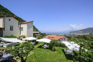 a view of a hotel with tables and white umbrellas at Casale Guarracino in Sant'Agnello