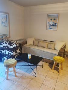 uma sala de estar com um sofá e duas cadeiras em Appartement Les Coches em La Plagne Tarentaise
