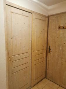 um quarto com 2 portas de madeira e piso em azulejo em Appartement Les Coches em La Plagne Tarentaise