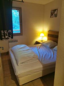 um quarto com uma cama branca e uma janela em Appartement Les Coches em La Plagne Tarentaise