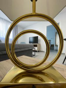 un espejo de oro sobre una mesa en la sala de estar en Apartamentos Lusitania Parking Gratis bajo disponibilidad, en Mérida