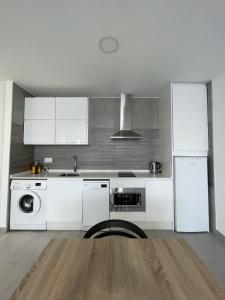 cocina con armarios blancos, fregadero y lavavajillas en Apartamentos Lusitania Parking Gratis bajo disponibilidad, en Mérida