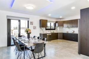 a kitchen and dining room with a table and chairs at Villa Elpida ONE by Ezoria Villas in Timi, Paphos in Ktima