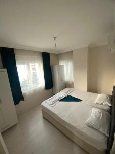- un lit blanc dans une chambre avec fenêtre dans l'établissement KARTALKAYA APART OTEL, à Antalya
