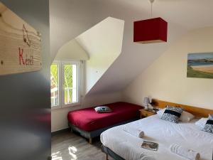 Un dormitorio con dos camas y una ventana. en Hotel Aux Tamaris, en Sauzon