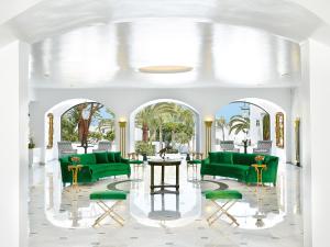 a living room with green couches and a table at Caramel Grecotel Boutique Resort in Adelianos Kampos
