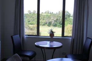 um quarto com uma mesa e duas cadeiras e uma janela em McLaren Lake View em Tauranga