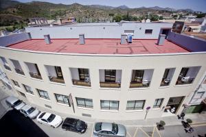 a large white building with cars parked in a parking lot at Hotel Beri in Llança