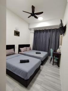 Suria Paradise Lodge في راناو: غرفة نوم بسريرين ومروحة سقف