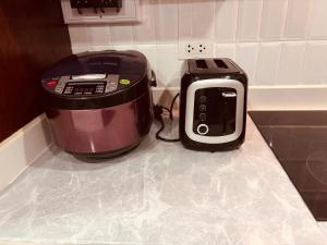 a slow cooker and a toaster sitting on a kitchen counter at Mano Residence esidence in Luang Prabang