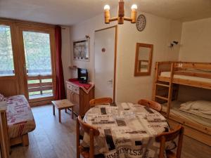 a dining room with a table and a bunk bed at Appartement La Plagne Montalbert , 2 pièces, 4 personnes - FR-1-755-4 in Aime-La Plagne