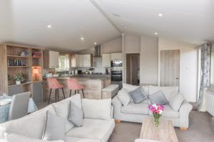 a living room with two couches and a kitchen at Long View in Roebeck Country Park, sleeps 4, beach 3.5 miles. in Ryde