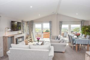 een woonkamer met witte meubels en een open haard bij Long View in Roebeck Country Park, sleeps 4, beach 3.5 miles. in Ryde