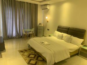 1 dormitorio con 1 cama grande y 1 mesa en EKOH'S PLACE, en Abuja