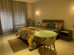 1 dormitorio con 1 cama, mesa y sillas en EKOH'S PLACE, en Abuja