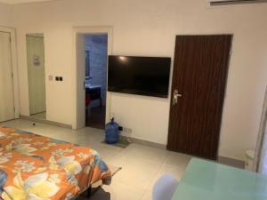 1 dormitorio con 1 cama y TV de pantalla plana en EKOH'S PLACE, en Abuja