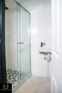 a glass shower in a bathroom with a sink at Chimas Guest House in Musina