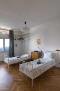 two beds in a room with wooden floors at Family apartment in the city centre - FREE parking garage in Ljubljana