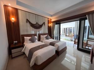 a bedroom with two beds and a large window at Grand Yuna Hotel Nusa Penida in Toyapakeh