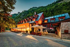 a large building with tables and chairs in front of it at Chata Pieniny in Lesnica