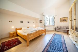 a bedroom with a wooden bed and a couch at 2403 Charmante Dachwohnung mit hohen Decken und Suedbalkon in Vulpera