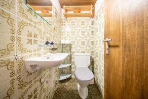 ein Badezimmer mit einem weißen WC und einem Waschbecken in der Unterkunft 2403 Charmante Dachwohnung mit hohen Decken und Suedbalkon in Vulpera