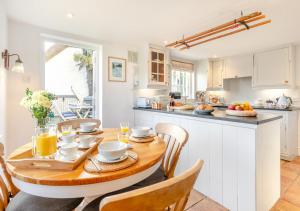 a kitchen with a wooden table and chairs at Popigale Cottage in Helford