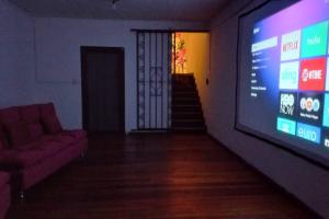 uma sala de estar com uma televisão grande e um sofá em Casa Corazón em Oaxaca de Juárez