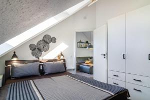 a bedroom with white walls and a bed with striped pillows at Ferienwohnung Romanas in Ostrach