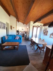 a living room with a blue couch and a table at Ventoux 24 in Enchastrayes
