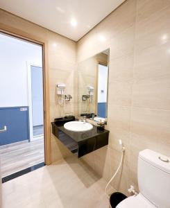 La salle de bains est pourvue d'un lavabo et de toilettes. dans l'établissement Kaira Boutique Hotel, à Duong Dong