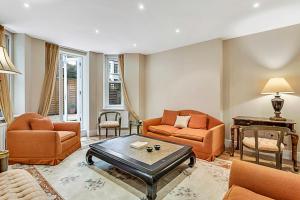 a living room with orange furniture and a table at Beautiful Abode in Kensington Olympia in London
