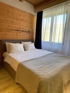 a bedroom with a large bed with a window at Ski in Ski out Slopeside apartments just 50 meters from the Gondola in New Gudauri in Gudauri