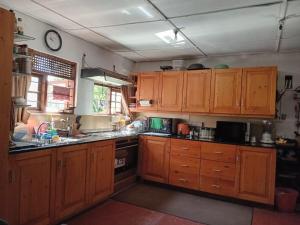 a kitchen with wooden cabinets and a stove top oven at SHADEY COTTAGE in Gampola