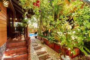 a house with a garden with plants and a pathway at Bungalow Phuket in Kamala Beach