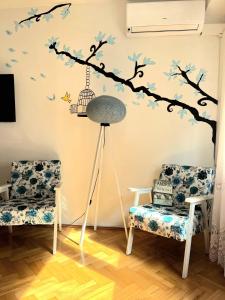 a room with a tree branch with birds and a bird cage at Center Apartment in Višegrad