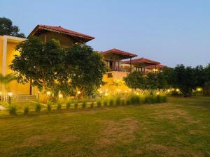 a house with lights in front of a yard at The Vanveda Resort By Nirvana in Sasan Gir