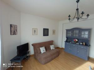 uma sala de estar com um sofá e uma televisão em Les 26 Tanneurs appartement em Noyon