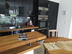 eine Küche mit schwarzen Schränken und einem Holztisch in der Unterkunft Domaine de la Caure in Bussière-Dunoise